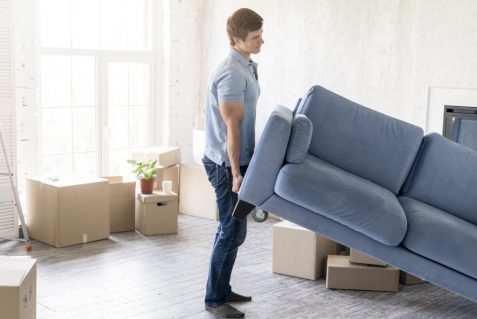 side-view-man-handling-couch-while-preparing-move-out (1)